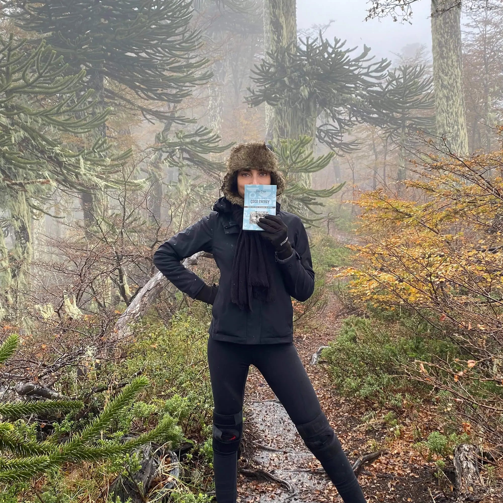 Mujer vestida de negro en bosque de araucarias sosteniendo trufas Da'Oro