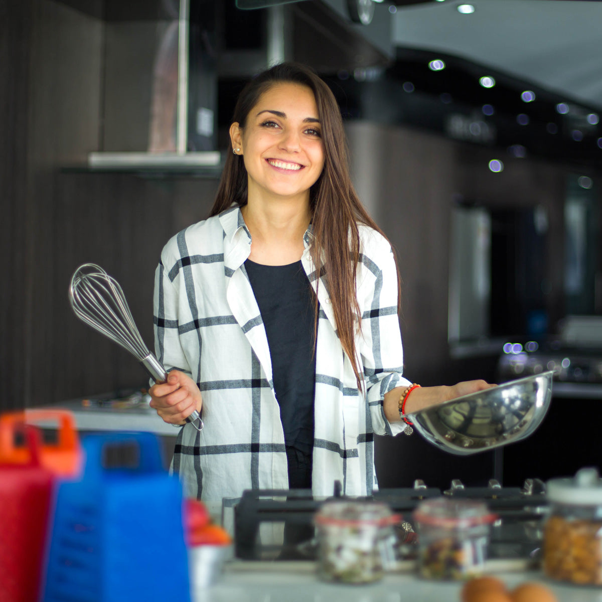 Mujer sonriendo con bowl y batidora en las manos