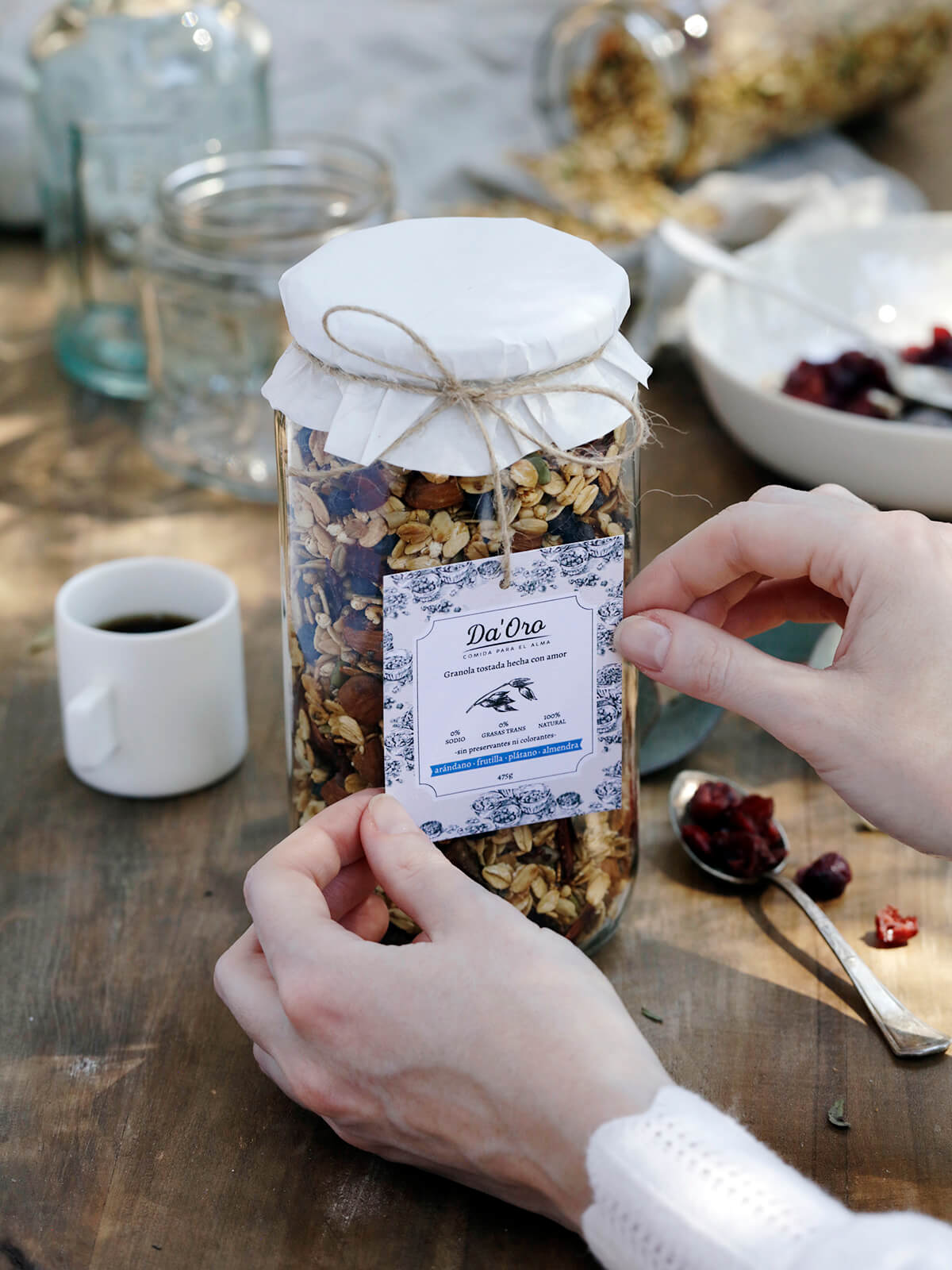 Manos afirmando etiqueta de frasco granola Da'Oro