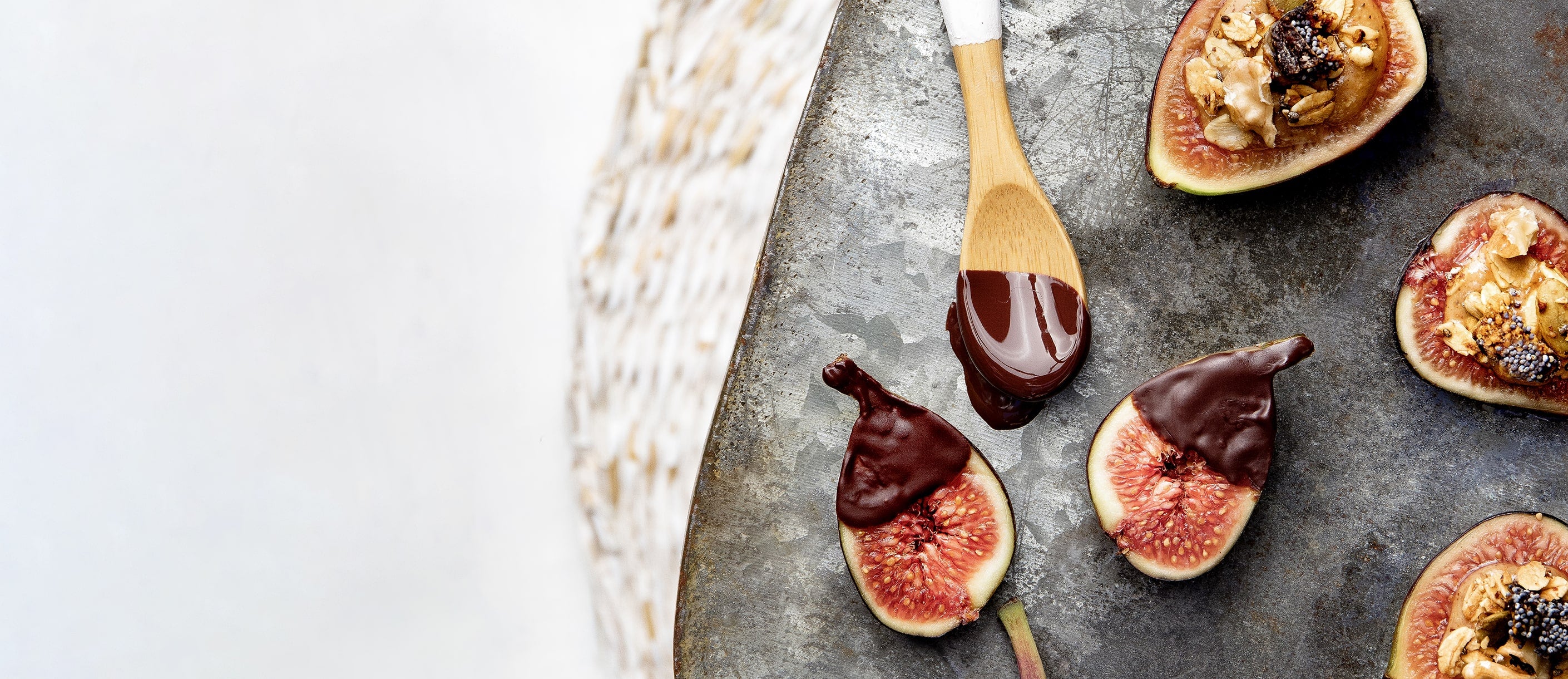 Mitades de higo con chocolate y granola sobre metal