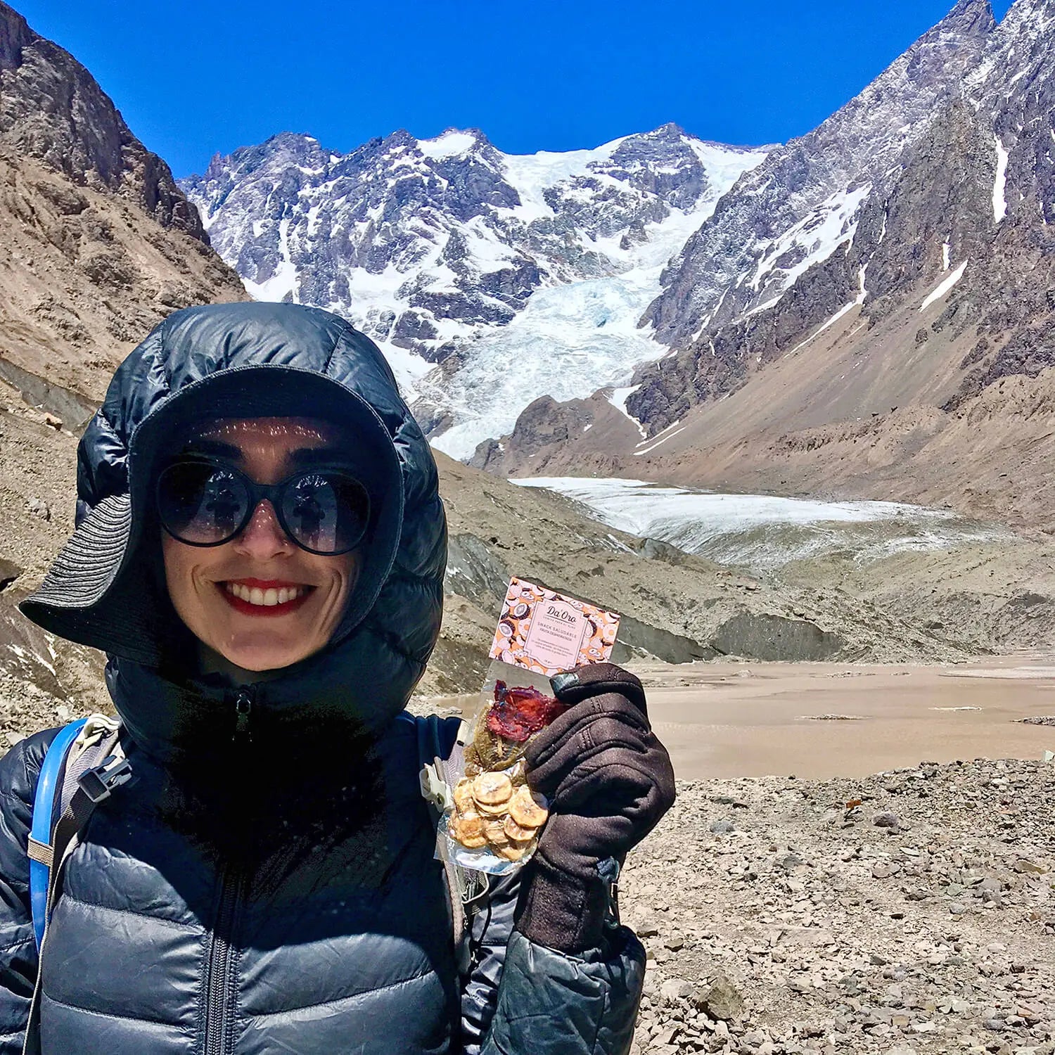 Mujer sosteniendo un snack Da'Oro en Glaciar Juncal