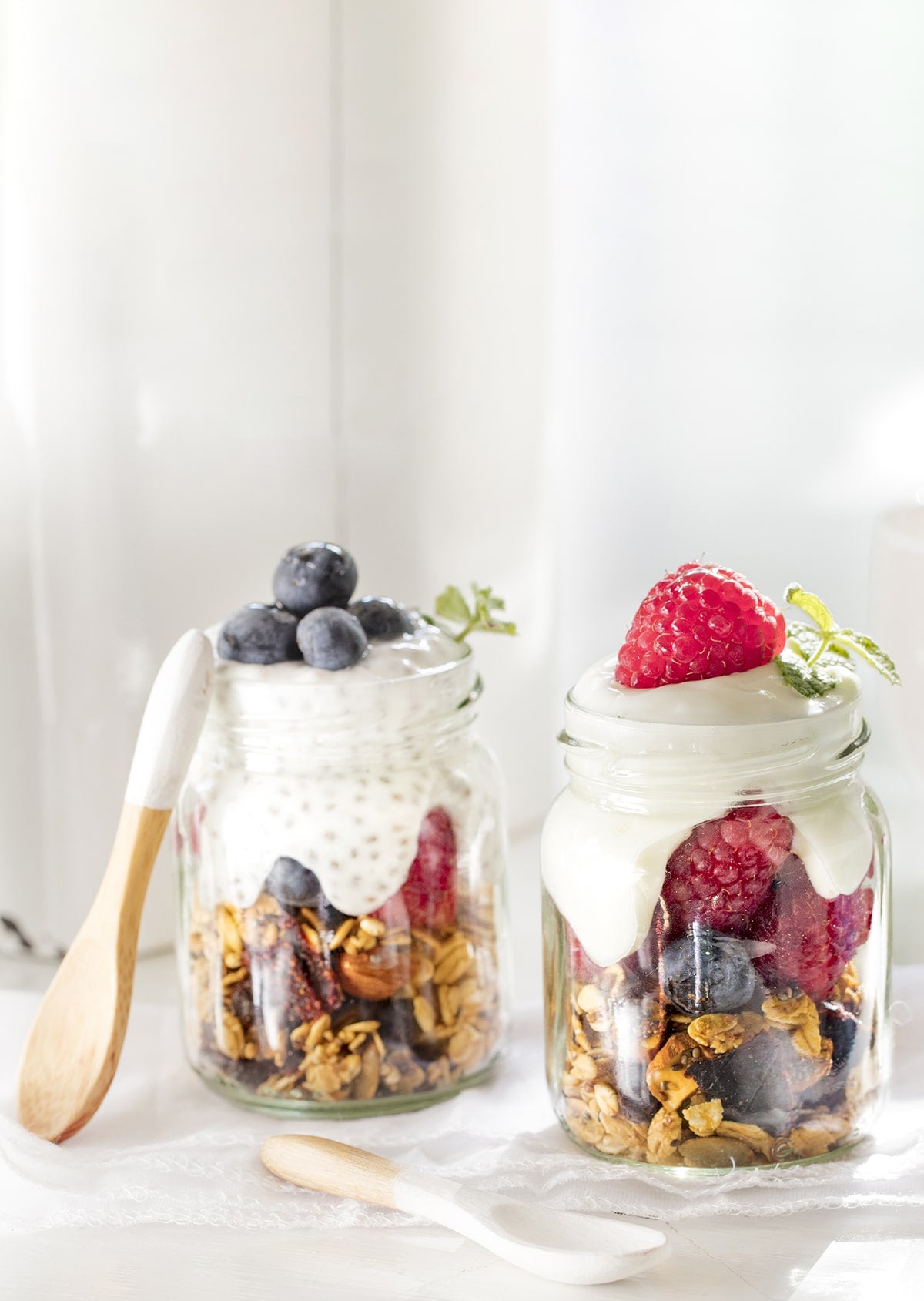 Dos vasos con granola frutos rojos y yogur